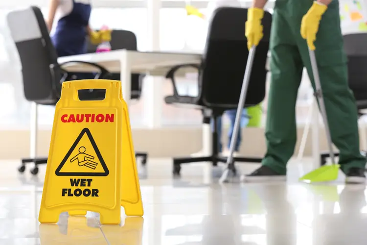 Photo showing a caution wet floor sign, while commercial cleaning is taking place